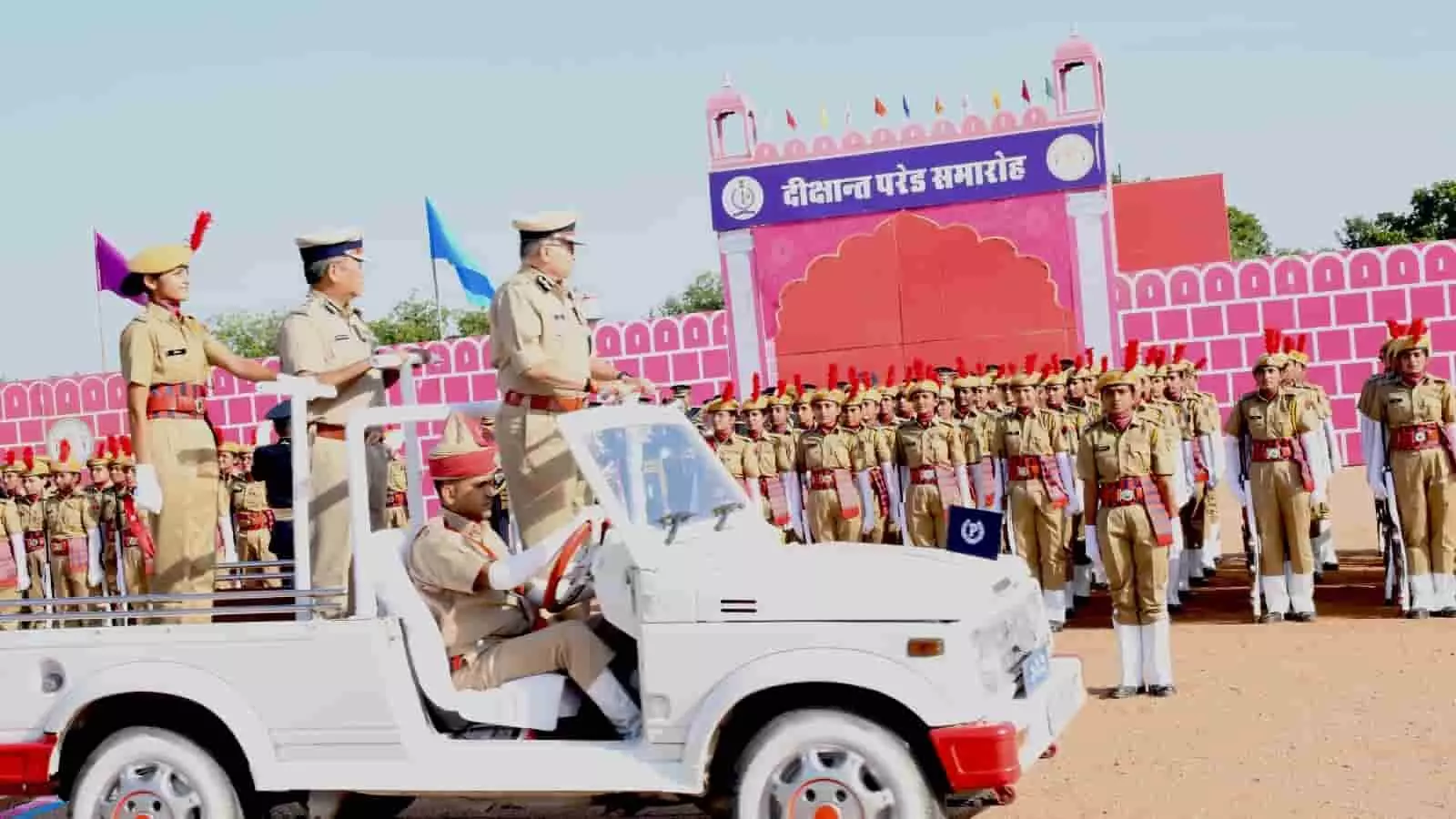 तस्वीर में खुली सफेद जीप पर सवार होकर पुलिस अधिकारी मैदान में परेड का निरीक्षण कर रहे हैं। तस्वीर में खुली सफेद जीप पर सवार होकर पुलिस अधिकारी मैदान में परेड का निरीक्षण कर रहे हैं।
