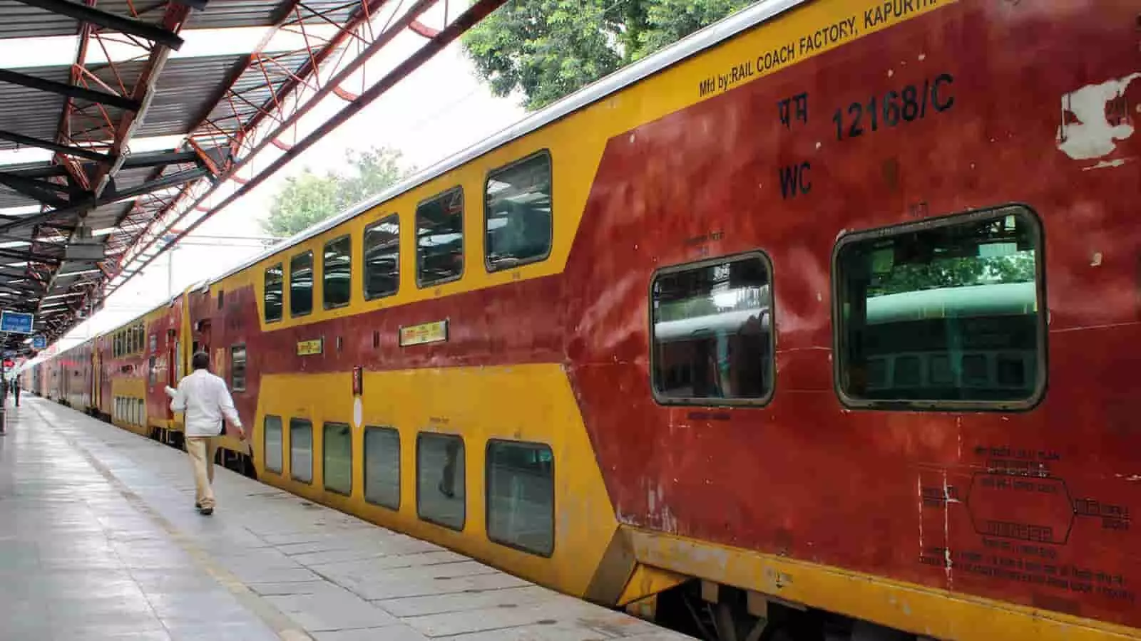 तस्वीर में रेलवे स्टेशन के प्लेटफॉर्म पर खड़ी ट्रेन और एक व्यक्ति दिखाई दे रहे हैं। तस्वीर में रेलवे स्टेशन के प्लेटफॉर्म पर खड़ी ट्रेन और एक व्यक्ति दिखाई दे रहे हैं।