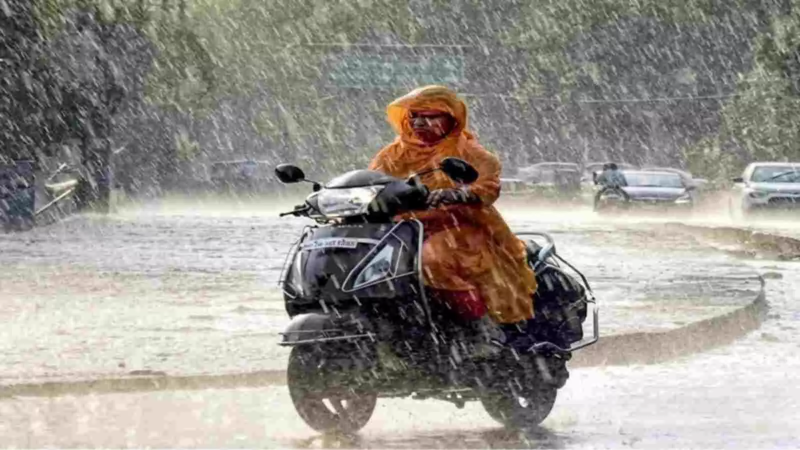 बारिश के दौरान रेनकोट पहनकर सड़क पर स्कूटर चलाती महिला। बारिश के दौरान रेनकोट पहनकर सड़क पर स्कूटर चलाती महिला।