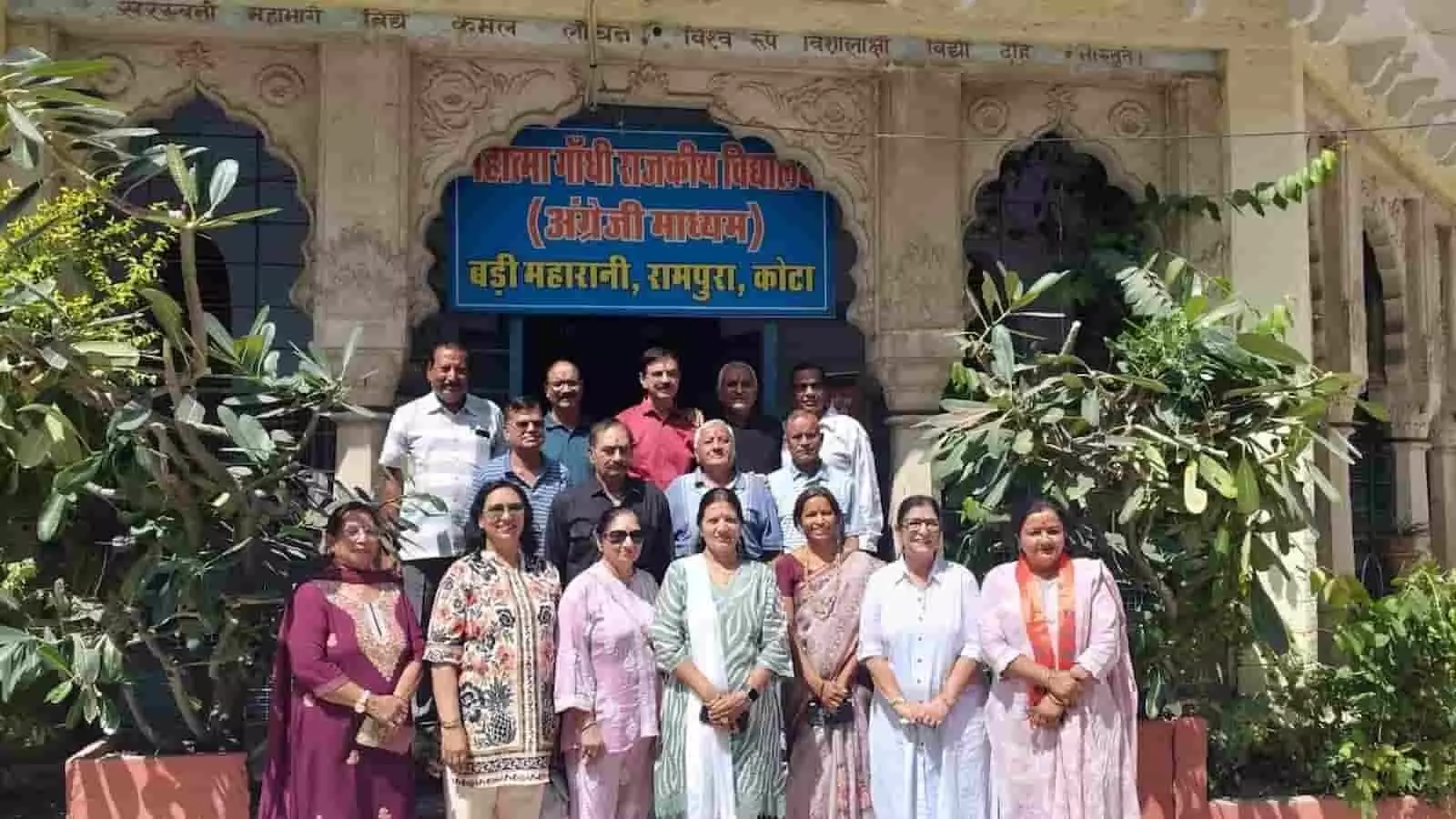 तस्वीर में दिख रही महिलाएं और पुरुष विद्यालय के मुख्य बोर्ड के सामने खड़े हैं। तस्वीर में दिख रही महिलाएं और पुरुष विद्यालय के मुख्य बोर्ड के सामने खड़े हैं।