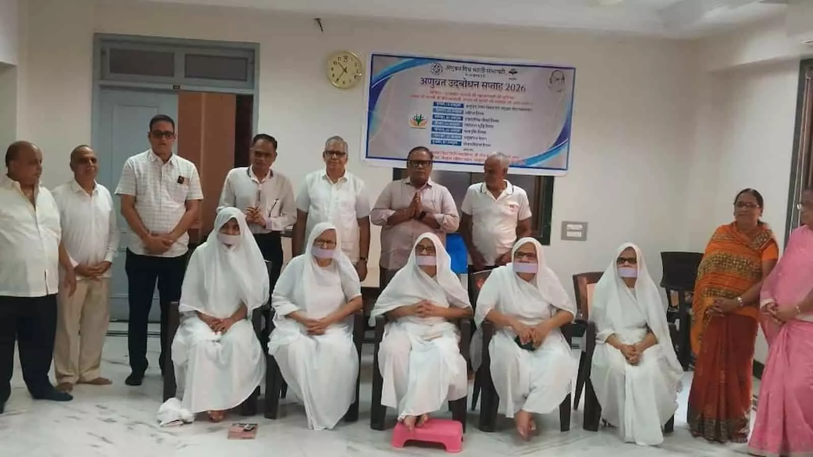 तस्वीर में अणुव्रत उद्घोषण सप्ताह बैनर के सामने बैठीं जैन साध्वियां और खड़े सदस्य दिख रहे हैं। तस्वीर में अणुव्रत उद्घोषण सप्ताह बैनर के सामने बैठीं जैन साध्वियां और खड़े सदस्य दिख रहे हैं।