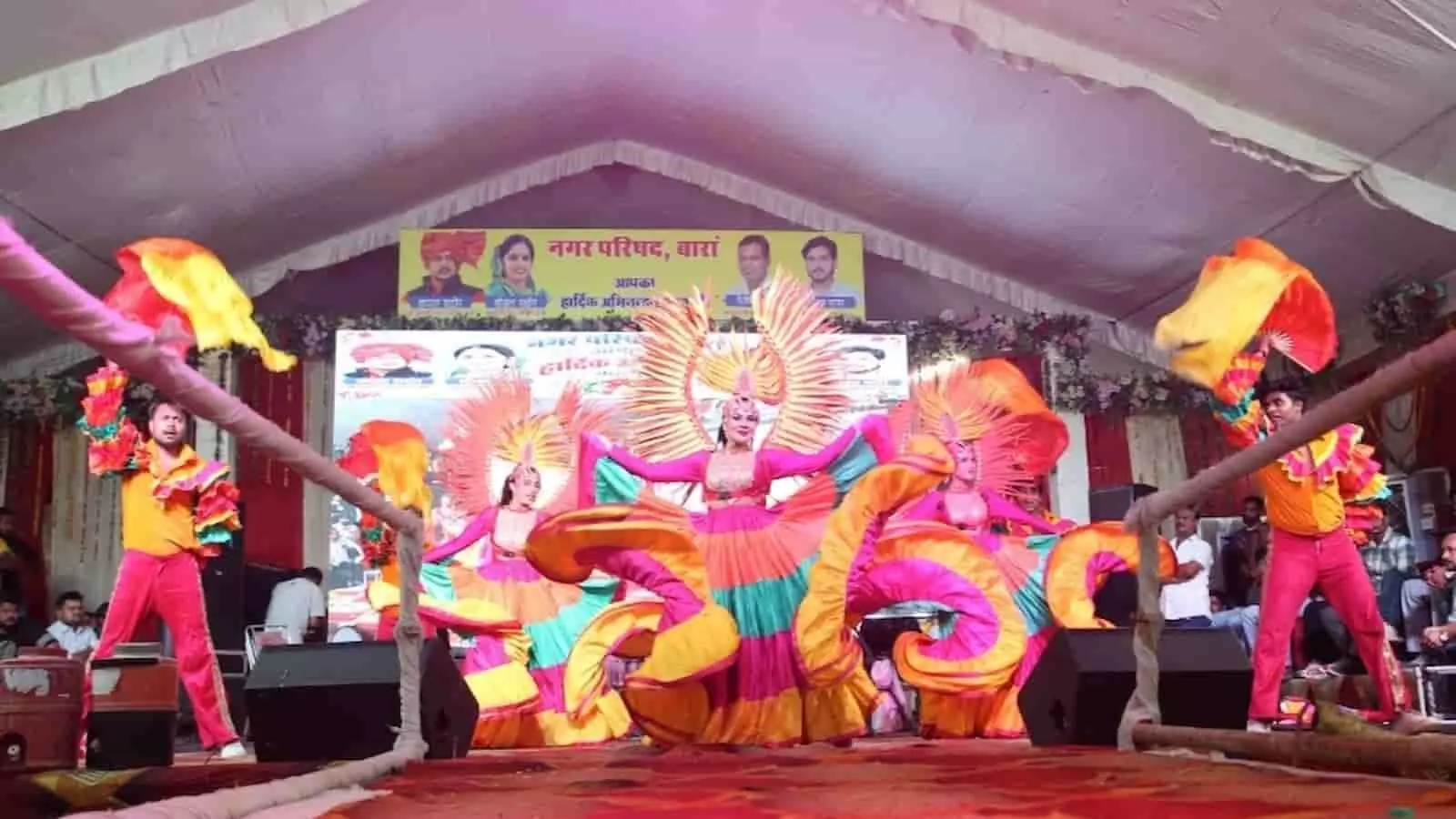 तस्वीर में मंच पर कलाकार नारंगी और गुलाबी पोशाक में नृत्य प्रस्तुति दे रहे हैं। तस्वीर में मंच पर कलाकार नारंगी और गुलाबी पोशाक में नृत्य प्रस्तुति दे रहे हैं।