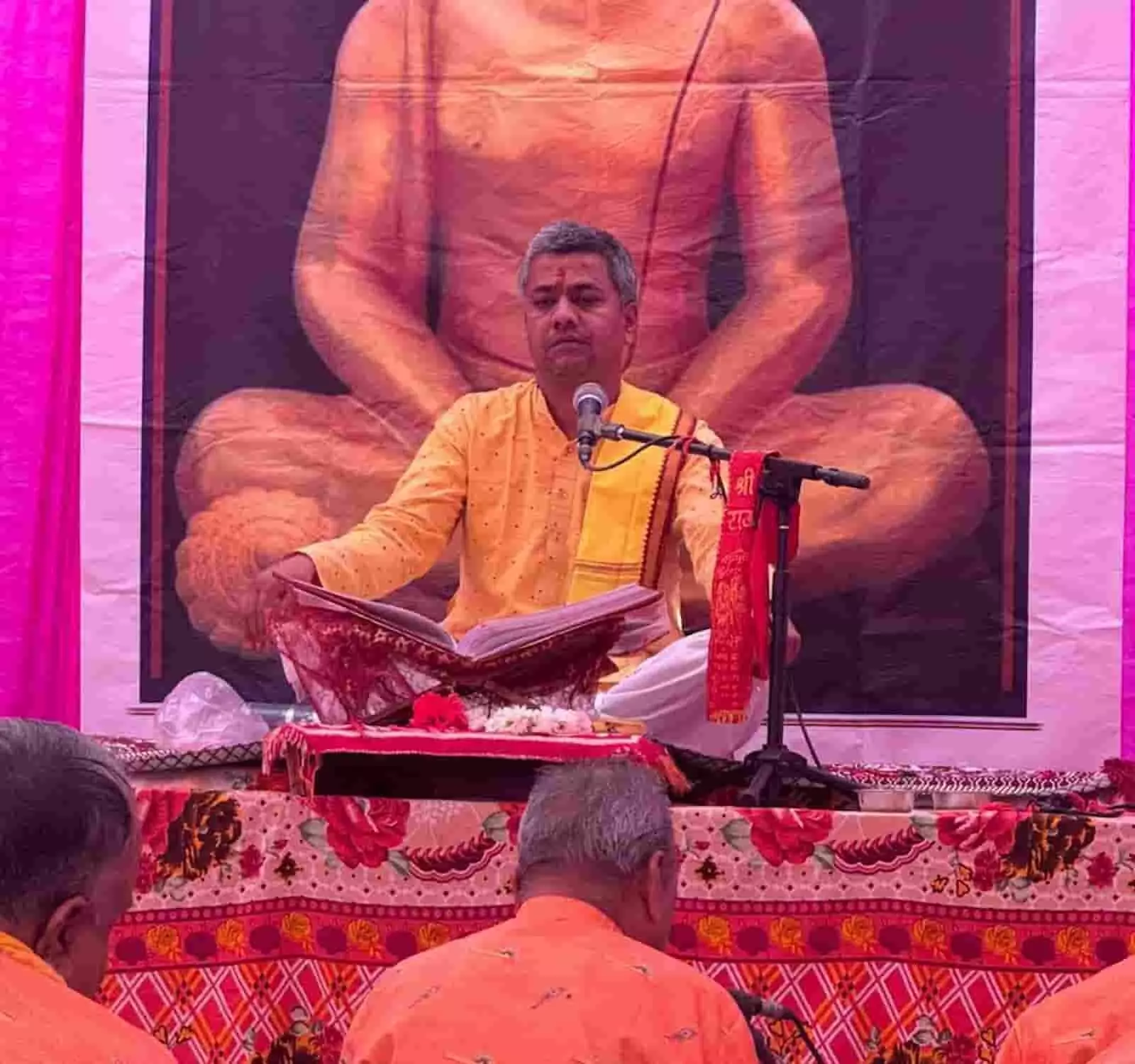 तस्वीर में मानस व्यास पं. अजय शर्मा माइक के सामने बैठकर धार्मिक पुस्तक पढ़ते हुए दिखाई दे रहे हैं। तस्वीर में मानस व्यास पं. अजय शर्मा माइक के सामने बैठकर धार्मिक पुस्तक पढ़ते हुए दिखाई दे रहे हैं।