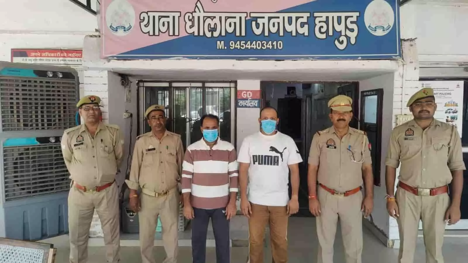 तस्वीर में बाएं से दाएं चार पुलिसकर्मियों के बीच मास्क पहने दो आरोपी खड़े दिख रहे हैं। तस्वीर में बाएं से दाएं चार पुलिसकर्मियों के बीच मास्क पहने दो आरोपी खड़े दिख रहे हैं।