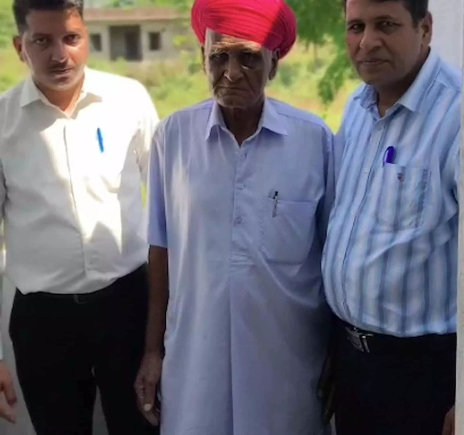 तस्वीर में बाएं से दाएं सफेद शर्ट में पुरुष, लाल पगड़ी में बुजुर्ग गोविंदराम और धारीदार शर्ट में पुरुष खड़े हैं। तस्वीर में बाएं से दाएं सफेद शर्ट में पुरुष, लाल पगड़ी में बुजुर्ग गोविंदराम और धारीदार शर्ट में पुरुष खड़े हैं।
