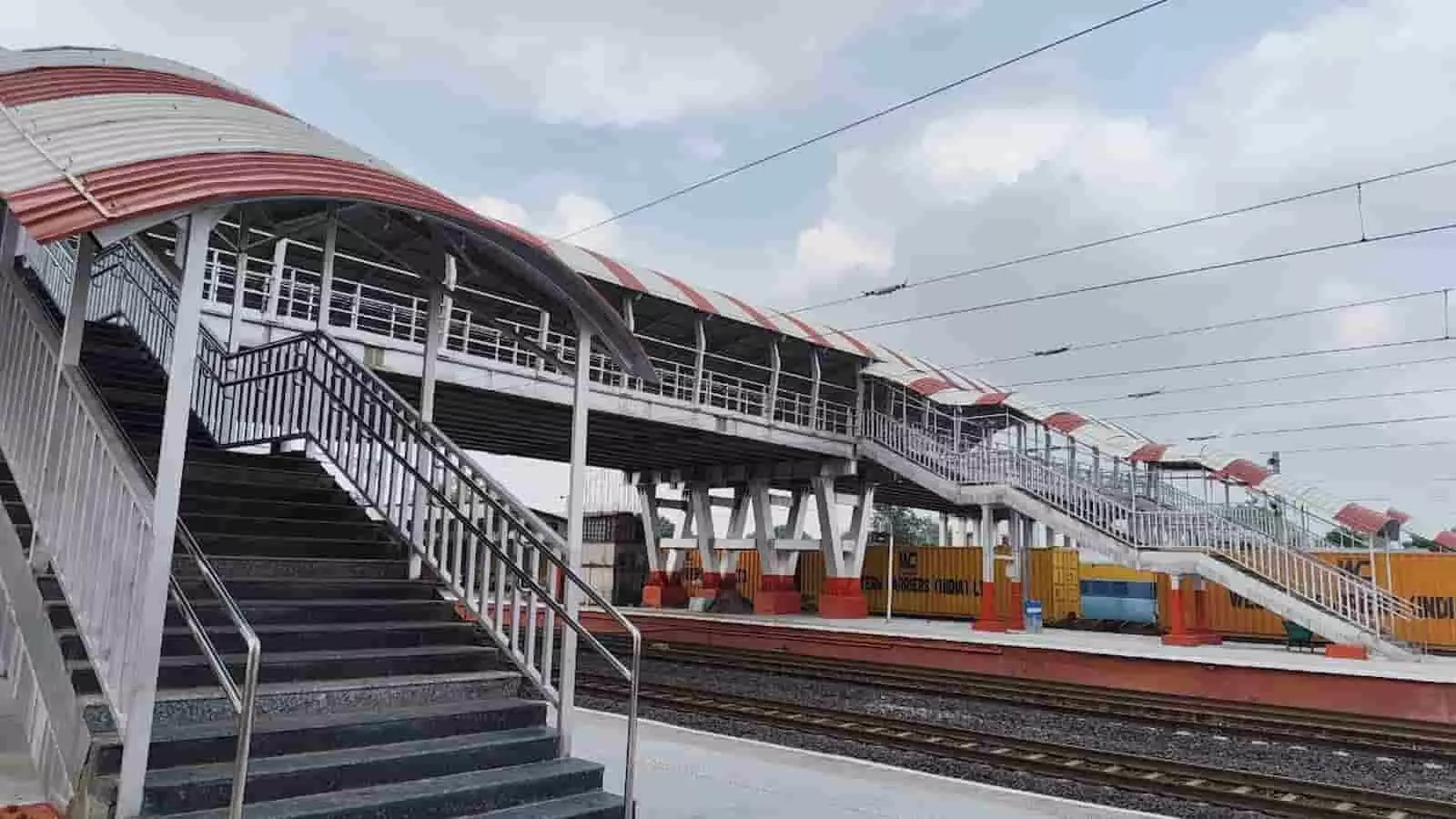 तस्वीर में दिख रही रेलवे पटरियों के ऊपर लाल और सफेद शेड वाला फुट ओवर ब्रिज बना है। तस्वीर में दिख रही रेलवे पटरियों के ऊपर लाल और सफेद शेड वाला फुट ओवर ब्रिज बना है।