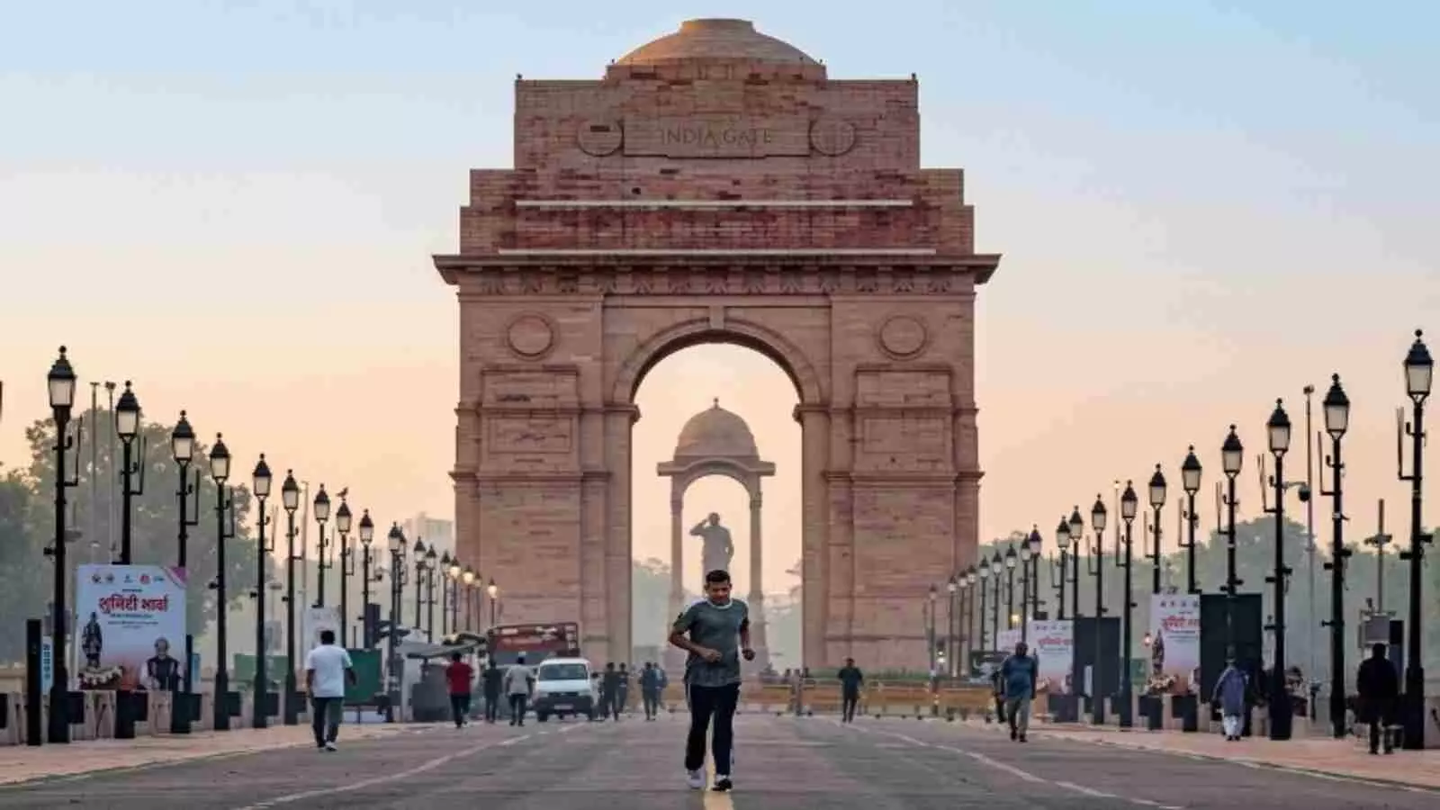 इंडिया गेट के सामने धुंधली हवा में सड़क पर दौड़ता हुआ व्यक्ति| इंडिया गेट के सामने धुंधली हवा में सड़क पर दौड़ता हुआ व्यक्ति|
