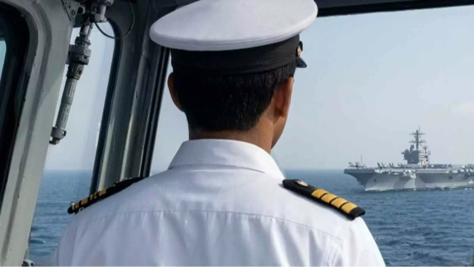 सफेद वर्दी में नौसेना अधिकारी कॉकपिट से समुद्र में दूर स्थित जहाज को देख रहा है| सफेद वर्दी में नौसेना अधिकारी कॉकपिट से समुद्र में दूर स्थित जहाज को देख रहा है|