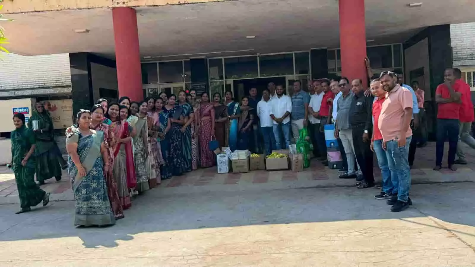 तस्वीर में अस्पताल की इमारत के सामने बाएँ से दाएँ खड़े अग्रवाल समाज के लोग और ज़मीन पर रखे फल-खाद्य सामग्री दिख रहे हैं। तस्वीर में अस्पताल की इमारत के सामने बाएँ से दाएँ खड़े अग्रवाल समाज के लोग और ज़मीन पर रखे फल-खाद्य सामग्री दिख रहे हैं।