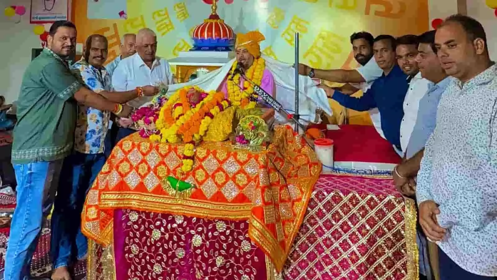 तस्वीर में कथा पंडाल में व्यास पीठ पर बैठे कथावाचक को विभिन्न लोग माला और शॉल पहना रहे हैं। तस्वीर में कथा पंडाल में व्यास पीठ पर बैठे कथावाचक को विभिन्न लोग माला और शॉल पहना रहे हैं।