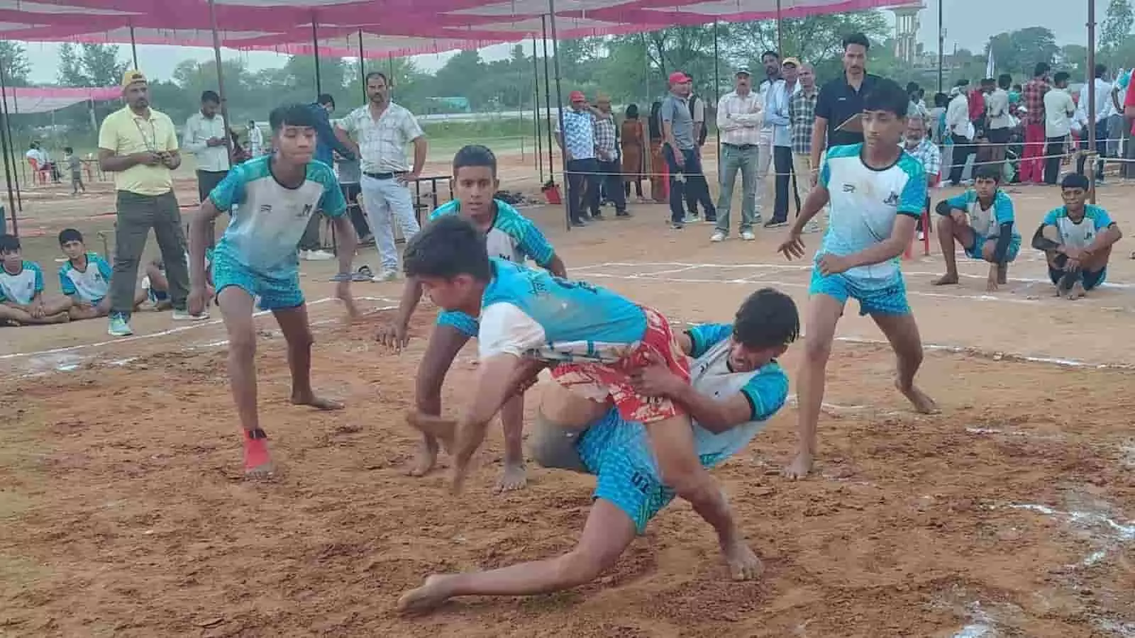 मैदान पर प्रतियोगिता के दौरान कबड्डी खेलते खिलाड़ी और दर्शक। मैदान पर प्रतियोगिता के दौरान कबड्डी खेलते खिलाड़ी और दर्शक।