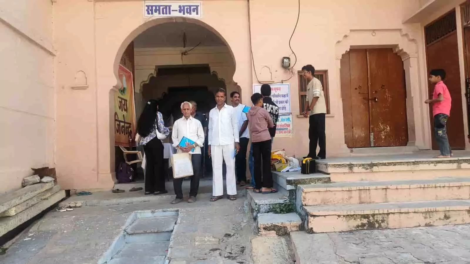 तस्वीर में समता भवन के मुख्य द्वार पर खड़े लोग और सीढ़ियों पर अन्य व्यक्ति नजर आ रहे हैं। तस्वीर में समता भवन के मुख्य द्वार पर खड़े लोग और सीढ़ियों पर अन्य व्यक्ति नजर आ रहे हैं।