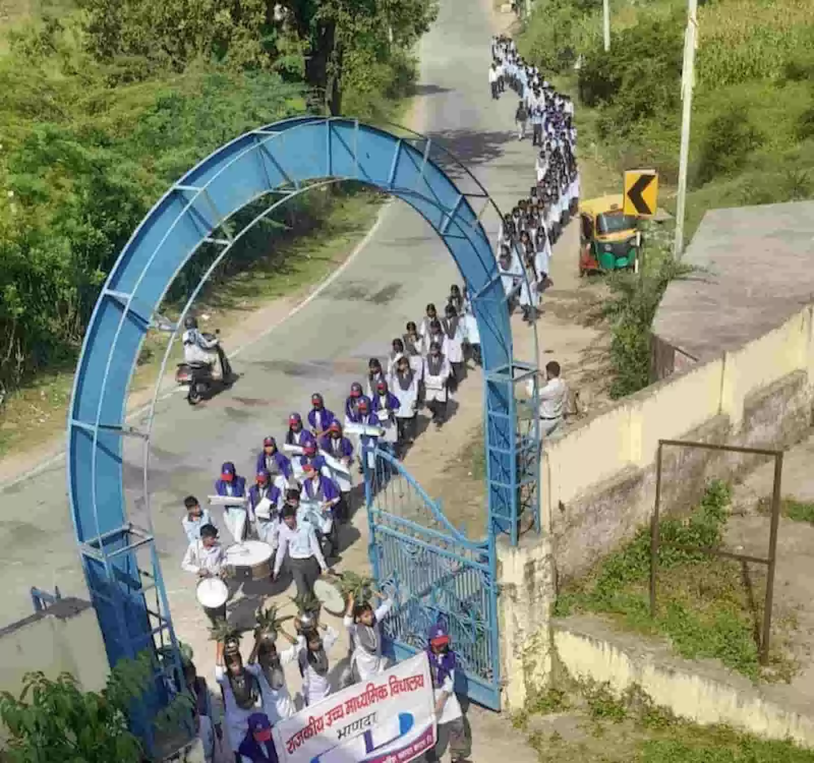 तस्वीर में नीले गेट से सिर पर कलश और स्कूल बैनर लिए छात्र सड़क पर रैली निकालते हुए दिखाई दे रहे हैं। तस्वीर में नीले गेट से सिर पर कलश और स्कूल बैनर लिए छात्र सड़क पर रैली निकालते हुए दिखाई दे रहे हैं।
