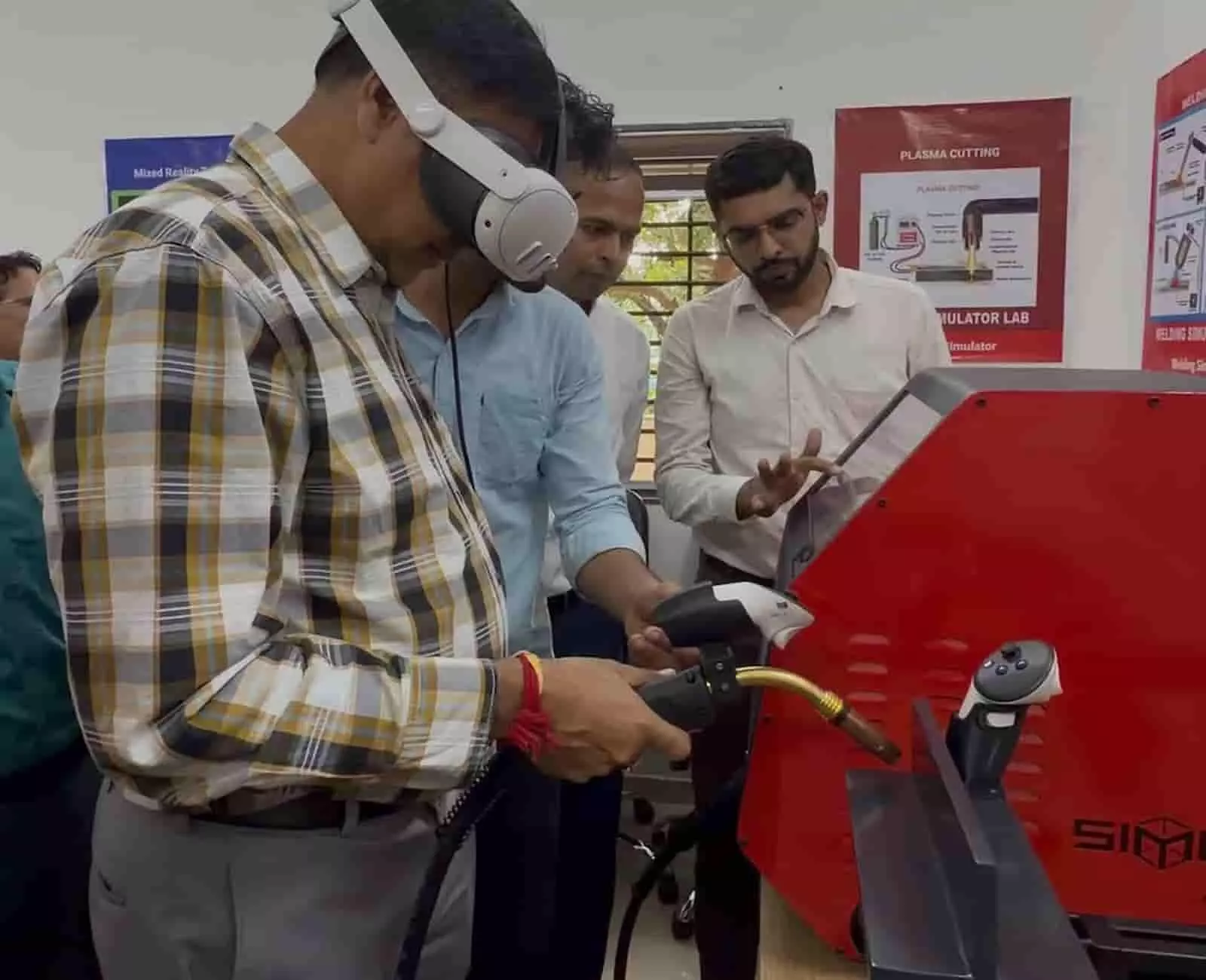 तस्वीर में एक व्यक्ति वीआर हेडसेट पहनकर वेल्डिंग टॉर्च से सिम्युलेटर पर अभ्यास कर रहा है। तस्वीर में एक व्यक्ति वीआर हेडसेट पहनकर वेल्डिंग टॉर्च से सिम्युलेटर पर अभ्यास कर रहा है।