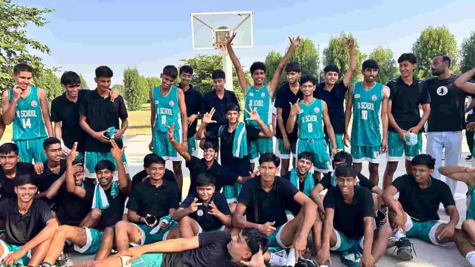 तस्वीर में दिख रही बास्केटबॉल टीम के युवा खिलाड़ी मैदान में एक साथ बैठकर और खड़े होकर खुशी जता रहे हैं। तस्वीर में दिख रही बास्केटबॉल टीम के युवा खिलाड़ी मैदान में एक साथ बैठकर और खड़े होकर खुशी जता रहे हैं।