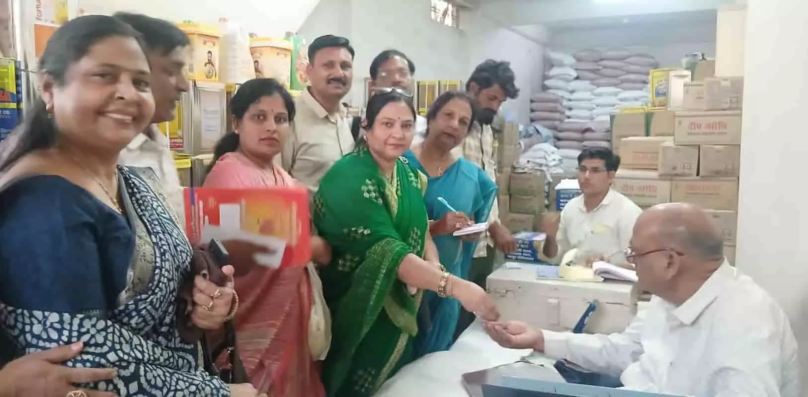 तस्वीर में महिला मंडल की सदस्याएं दुकान में बैठे व्यक्ति को पीले चावल और निमंत्रण देती दिख रही हैं। तस्वीर में महिला मंडल की सदस्याएं दुकान में बैठे व्यक्ति को पीले चावल और निमंत्रण देती दिख रही हैं।