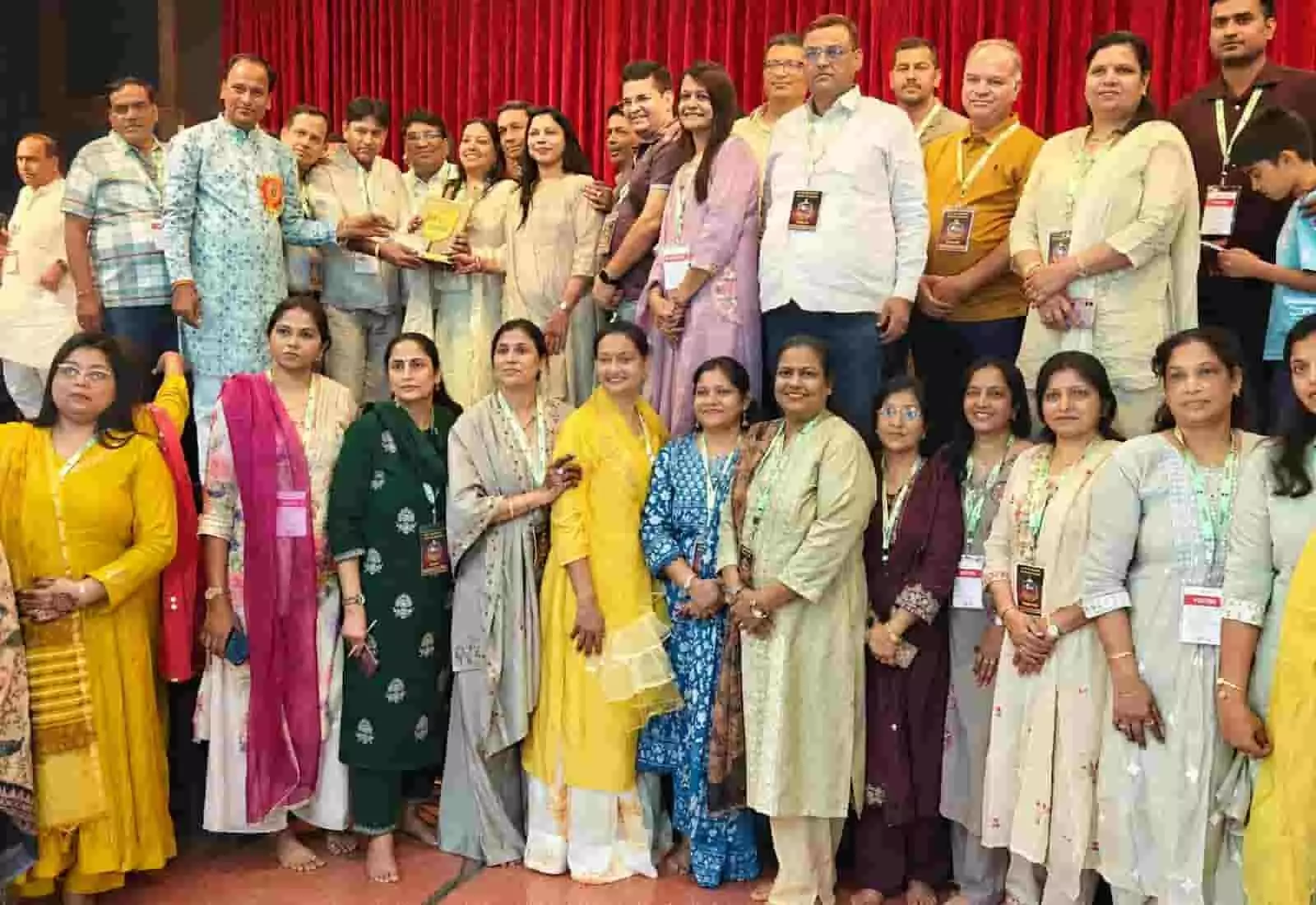 तस्वीर में दाएं से बाएं खड़े महिला-पुरुष सदस्य एक साथ खड़े होकर स्मृति चिन्ह पकड़े हुए हैं। तस्वीर में दाएं से बाएं खड़े महिला-पुरुष सदस्य एक साथ खड़े होकर स्मृति चिन्ह पकड़े हुए हैं।