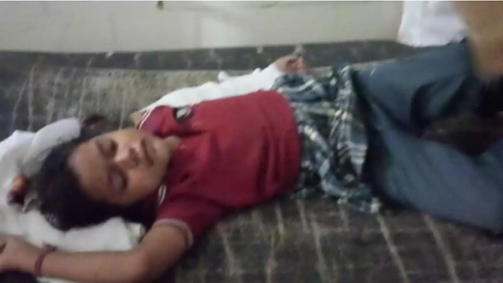 तस्वीर में अस्पताल के बेड पर लेटी लाल टी-शर्ट और यूनिफॉर्म पहने एक घायल स्कूली छात्रा दिखाई दे रही है। तस्वीर में अस्पताल के बेड पर लेटी लाल टी-शर्ट और यूनिफॉर्म पहने एक घायल स्कूली छात्रा दिखाई दे रही है।