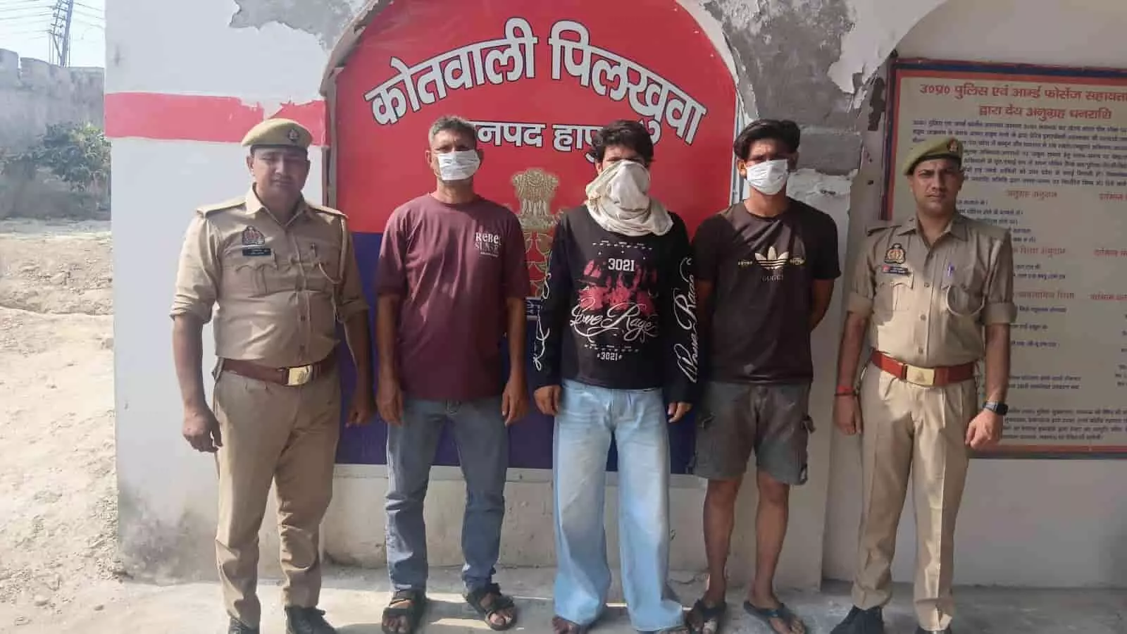 तस्वीर में बाएं से दाएं दो पुलिसकर्मियों के बीच खड़े मुंह ढके तीन गिरफ्तार आरोपी दिखाई दे रहे हैं। तस्वीर में बाएं से दाएं दो पुलिसकर्मियों के बीच खड़े मुंह ढके तीन गिरफ्तार आरोपी दिखाई दे रहे हैं।