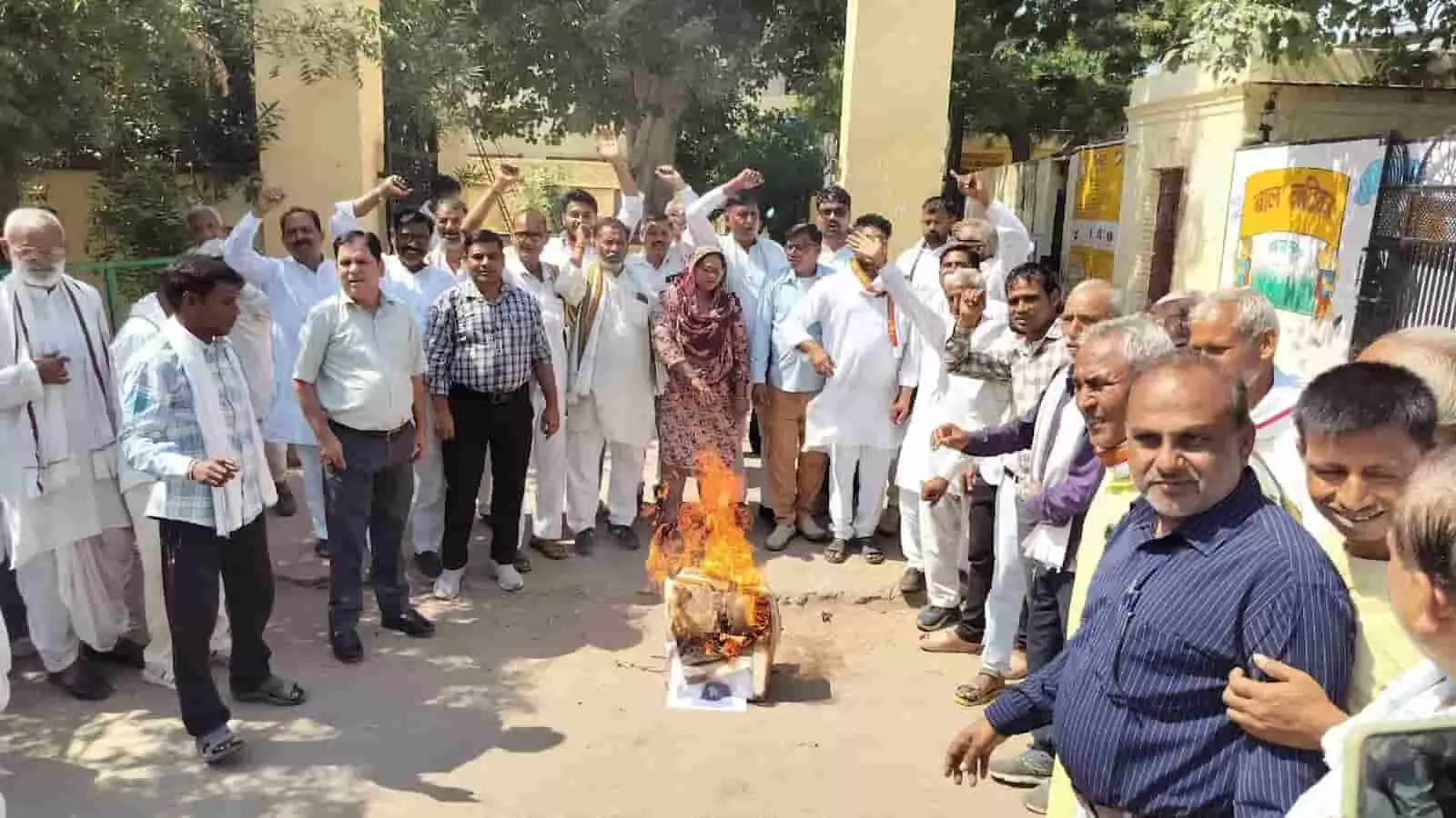तस्वीर में दिख रही जगह पर कई लोग हाथ उठाकर नारेबाजी कर रहे हैं और बीच में जलता हुआ पुतला रखा हुआ है। तस्वीर में दिख रही जगह पर कई लोग हाथ उठाकर नारेबाजी कर रहे हैं और बीच में जलता हुआ पुतला रखा हुआ है।
