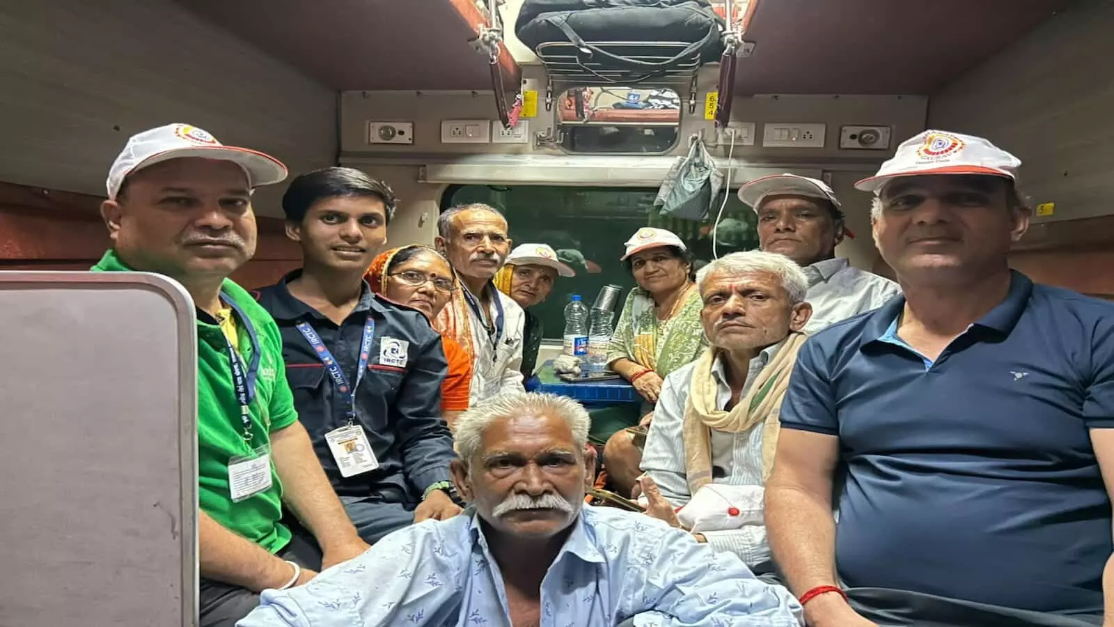 तस्वीर में ट्रेन के डिब्बे में बैठे वरिष्ठ यात्री और अन्य लोग दिखाई दे रहे हैं। तस्वीर में ट्रेन के डिब्बे में बैठे वरिष्ठ यात्री और अन्य लोग दिखाई दे रहे हैं।