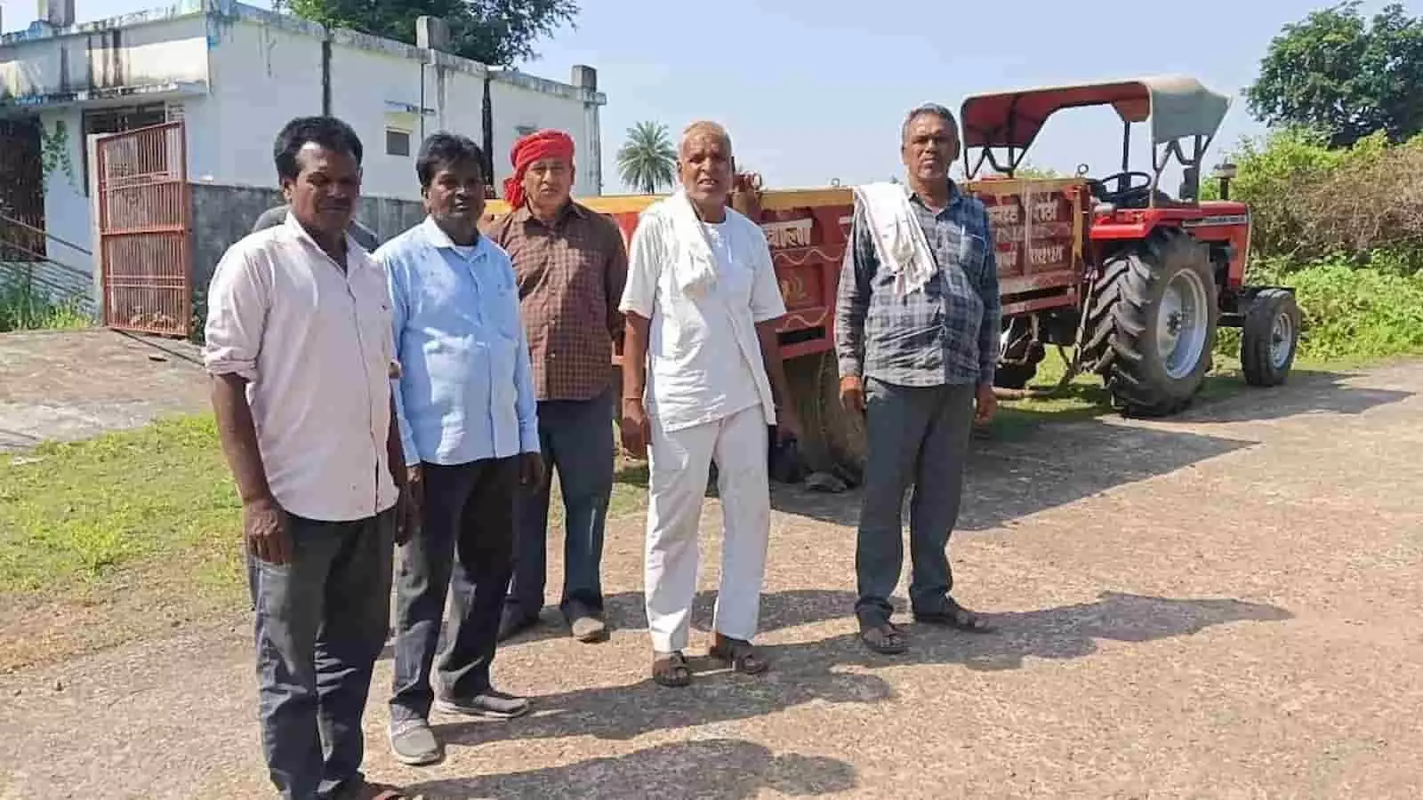 तस्वीर में पांच ग्रामीण एक साथ खड़े हैं और उनके पीछे एक लाल ट्रैक्टर खड़ा है। तस्वीर में पांच ग्रामीण एक साथ खड़े हैं और उनके पीछे एक लाल ट्रैक्टर खड़ा है।