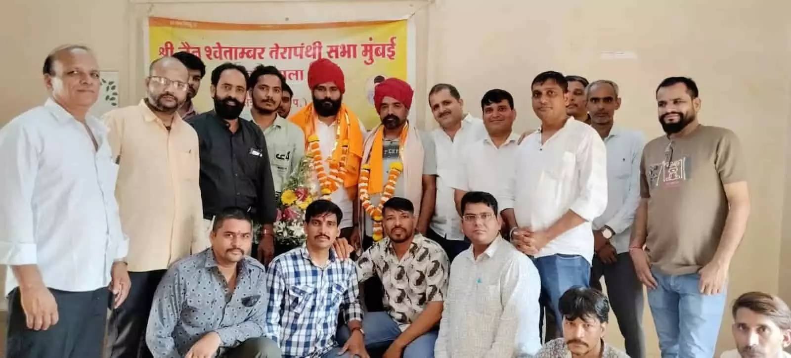तस्वीर में साफा और माला पहने खड़े लोगों के साथ अन्य लोग समूह में दिखाई दे रहे हैं। तस्वीर में साफा और माला पहने खड़े लोगों के साथ अन्य लोग समूह में दिखाई दे रहे हैं।