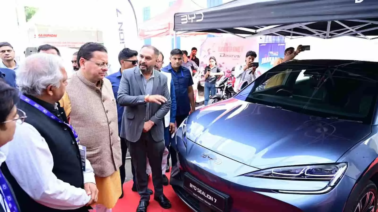 तस्वीर में बाएँ से दाएँ मुख्यमंत्री पुष्कर सिंह धामी और अन्य प्रतिनिधि प्रदर्शनी स्थल पर खड़ी नीली कार का निरीक्षण कर रहे हैं। तस्वीर में बाएँ से दाएँ मुख्यमंत्री पुष्कर सिंह धामी और अन्य प्रतिनिधि प्रदर्शनी स्थल पर खड़ी नीली कार का निरीक्षण कर रहे हैं।