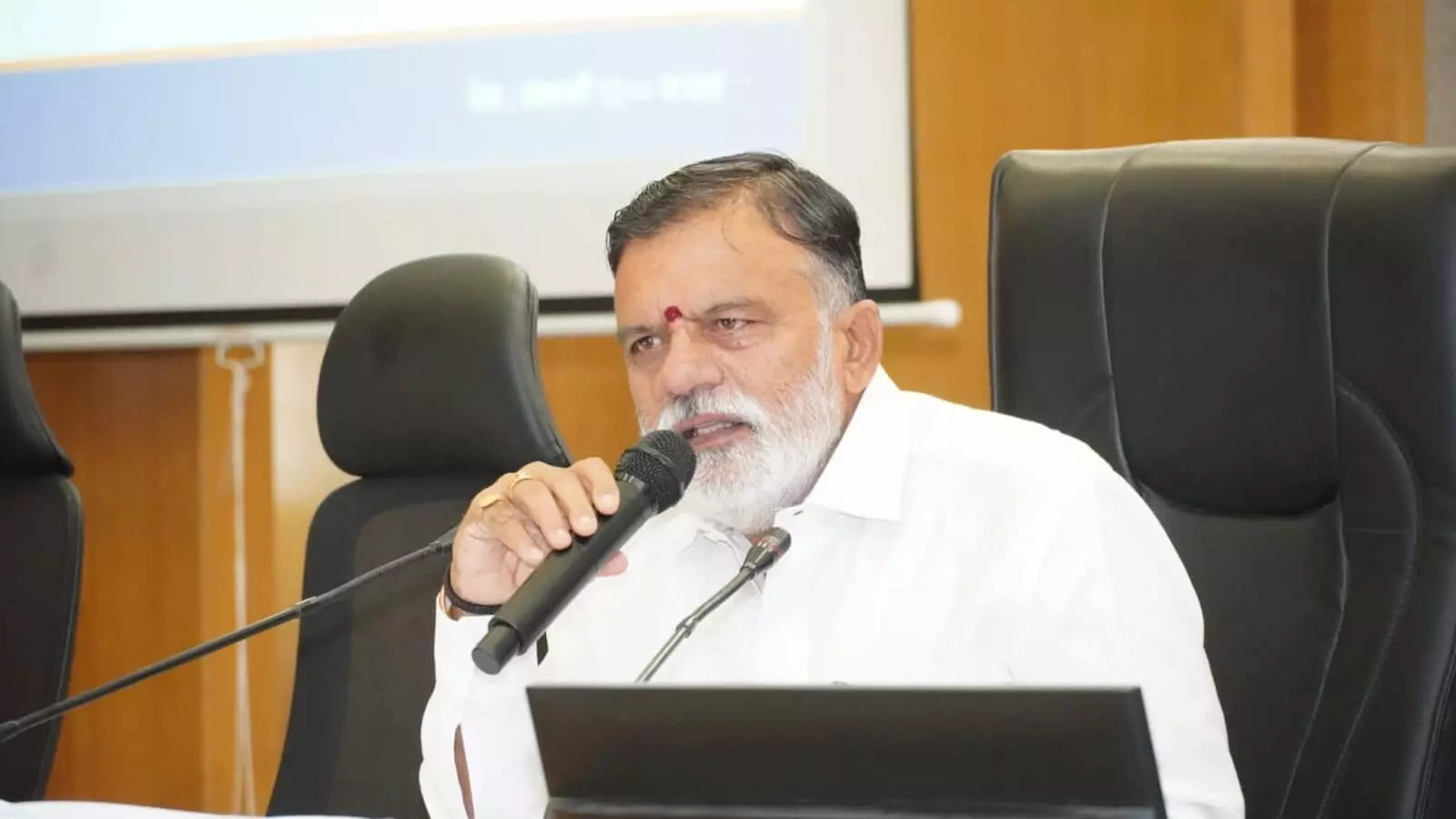 तस्वीर में सांसद राजाभाऊ वाजे एक बैठक के दौरान कुर्सी पर बैठकर माइक से संबोधित कर रहे हैं। तस्वीर में सांसद राजाभाऊ वाजे एक बैठक के दौरान कुर्सी पर बैठकर माइक से संबोधित कर रहे हैं।