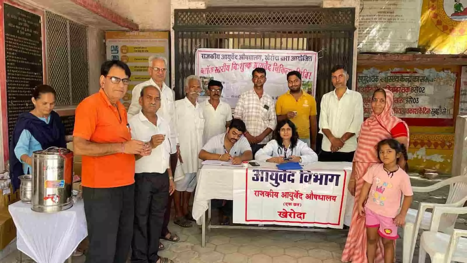 तस्वीर में राजकीय आयुर्वेद औषधालय खेरोदा में डॉक्टर, स्वास्थ्यकर्मी टेबल पर बैठे और आसपास खड़े ग्रामीण दिख रहे हैं। तस्वीर में राजकीय आयुर्वेद औषधालय खेरोदा में डॉक्टर, स्वास्थ्यकर्मी टेबल पर बैठे और आसपास खड़े ग्रामीण दिख रहे हैं।