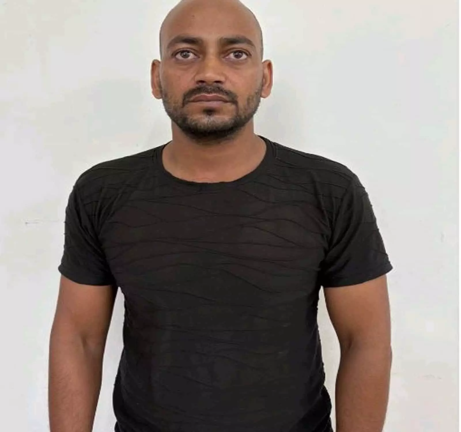 तस्वीर में दिख रही सफेद पृष्ठभूमि के आगे काली टी-शर्ट पहने एक पुरुष की तस्वीर। तस्वीर में दिख रही सफेद पृष्ठभूमि के आगे काली टी-शर्ट पहने एक पुरुष की तस्वीर।