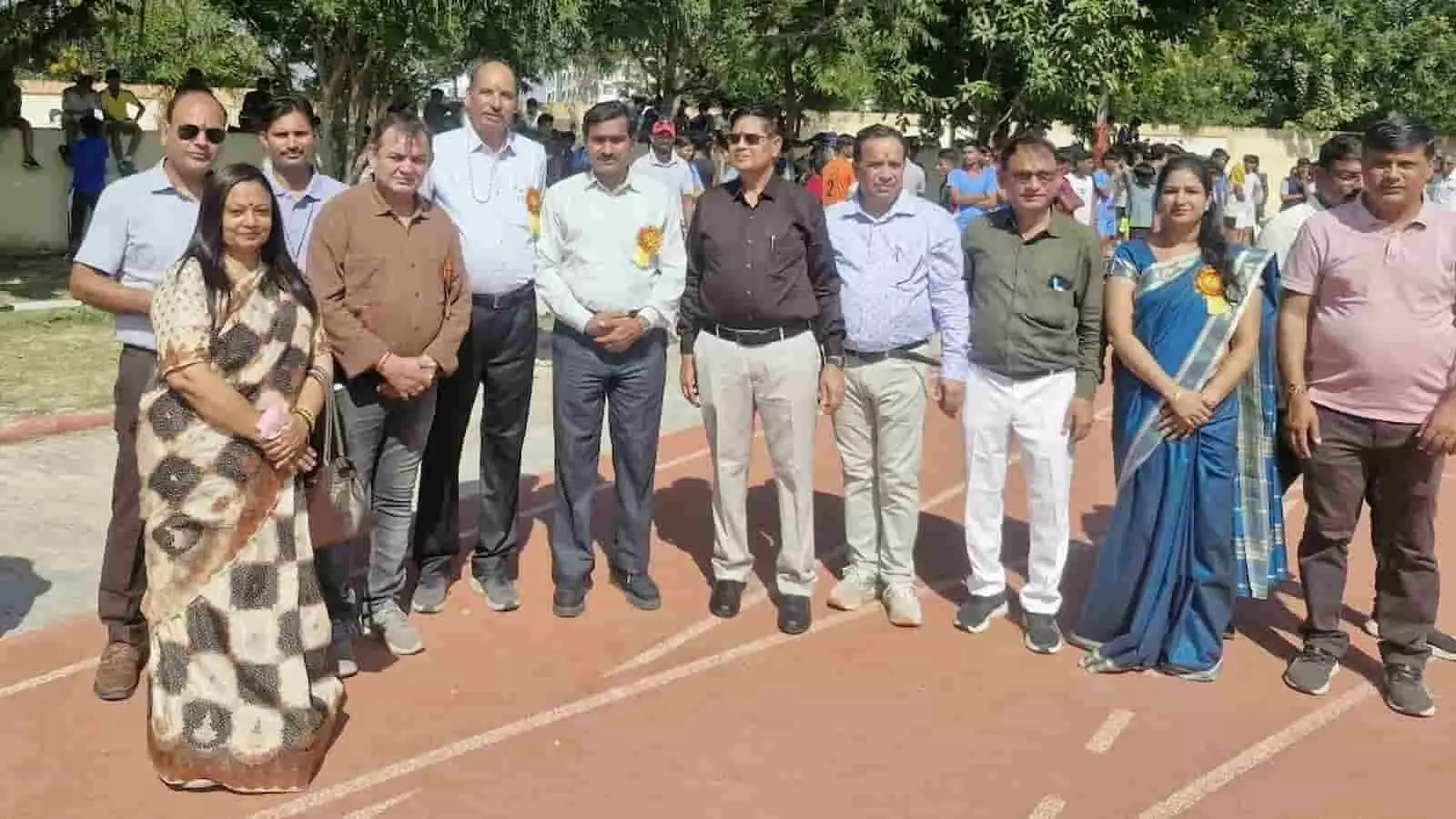 तस्वीर में खेल मैदान के रनिंग ट्रैक पर कई अतिथि और अधिकारी एक साथ खड़े हैं। तस्वीर में खेल मैदान के रनिंग ट्रैक पर कई अतिथि और अधिकारी एक साथ खड़े हैं।