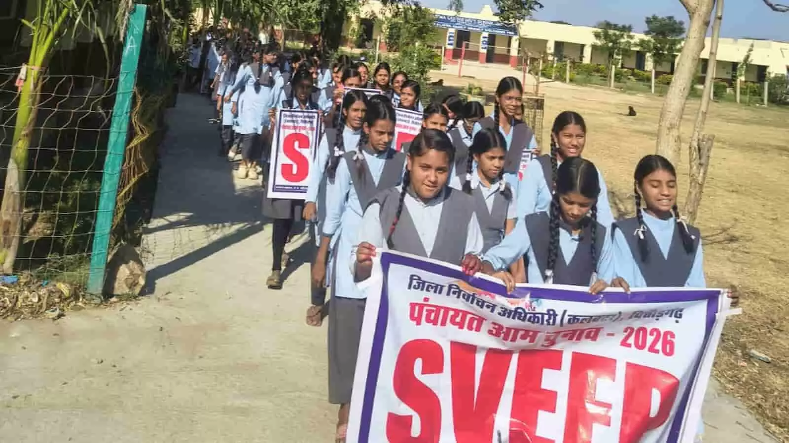 तस्वीर में नीली यूनिफॉर्म पहने छात्राएं हाथों में स्वीप का बैनर लिए पैदल मार्च कर रही हैं। तस्वीर में नीली यूनिफॉर्म पहने छात्राएं हाथों में स्वीप का बैनर लिए पैदल मार्च कर रही हैं।