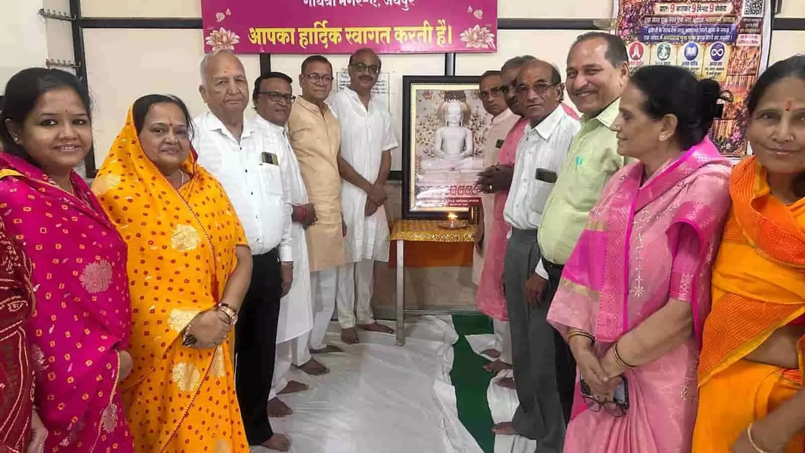 तस्वीर में एक बैनर और तस्वीर के सामने हाथ जोड़कर खड़े कई महिला और पुरुष श्रद्धालु दिखाई दे रहे हैं। तस्वीर में एक बैनर और तस्वीर के सामने हाथ जोड़कर खड़े कई महिला और पुरुष श्रद्धालु दिखाई दे रहे हैं।