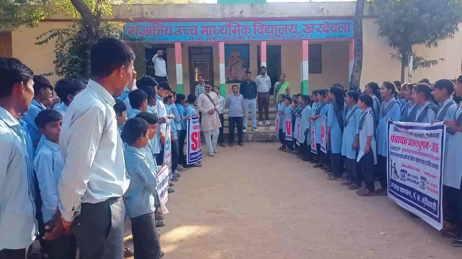 राजकीय उच्च माध्यमिक विद्यालय खरदेवला के प्रांगण में खड़े स्कूली छात्र और स्वीप टीम के सदस्य मतदाता जागरूकता बैनर के साथ। राजकीय उच्च माध्यमिक विद्यालय खरदेवला के प्रांगण में खड़े स्कूली छात्र और स्वीप टीम के सदस्य मतदाता जागरूकता बैनर के साथ।