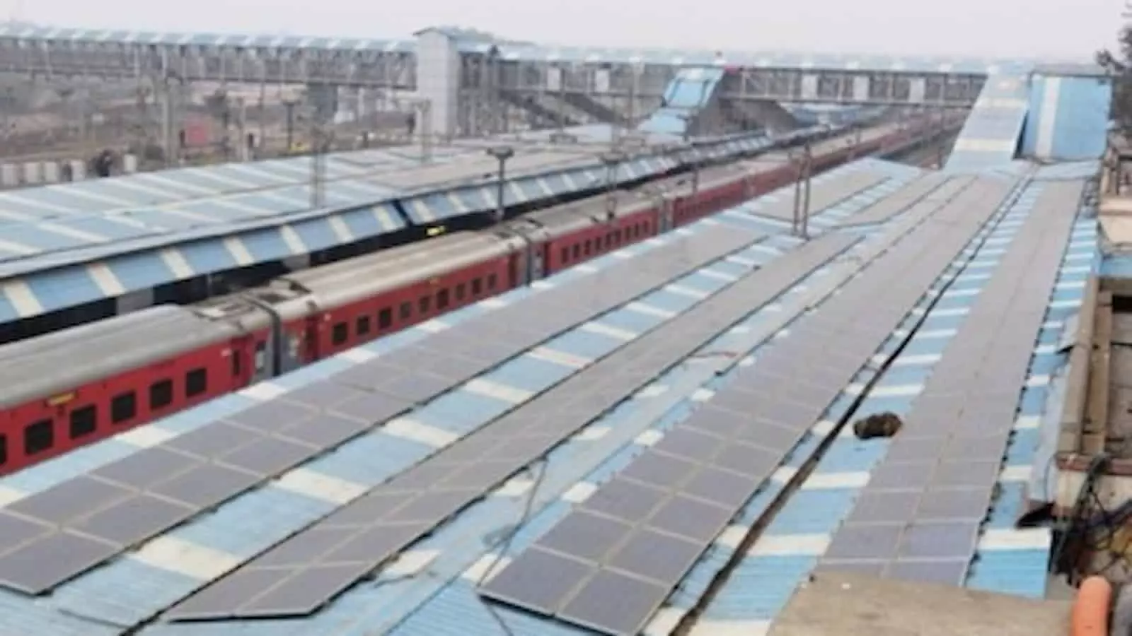 तस्वीर में रेलवे स्टेशन की छत पर स्थापित सौर पैनल और ट्रैक पर खड़ी ट्रेन दिखाई दे रही है। तस्वीर में रेलवे स्टेशन की छत पर स्थापित सौर पैनल और ट्रैक पर खड़ी ट्रेन दिखाई दे रही है।