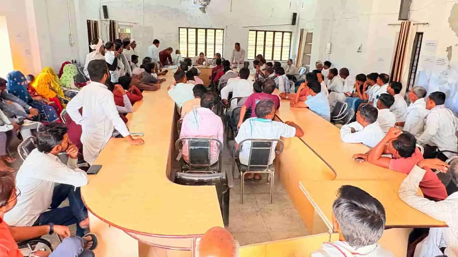 सभागार में टेबल पर बैठकर प्रबोधन कार्यशाला में हिस्सा लेते अधिकारी और लोग। सभागार में टेबल पर बैठकर प्रबोधन कार्यशाला में हिस्सा लेते अधिकारी और लोग।