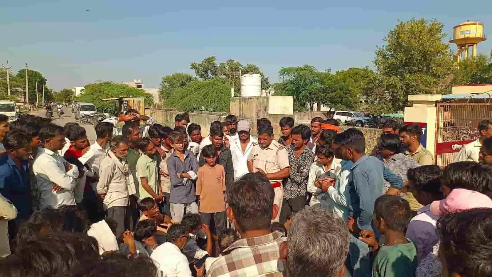 तस्वीर में बड़ी संख्या में ग्रामीण साड़ास थाने के मुख्य द्वार के बाहर पुलिसकर्मियों की मौजूदगी में एकत्रित हैं. तस्वीर में बड़ी संख्या में ग्रामीण साड़ास थाने के मुख्य द्वार के बाहर पुलिसकर्मियों की मौजूदगी में एकत्रित हैं.