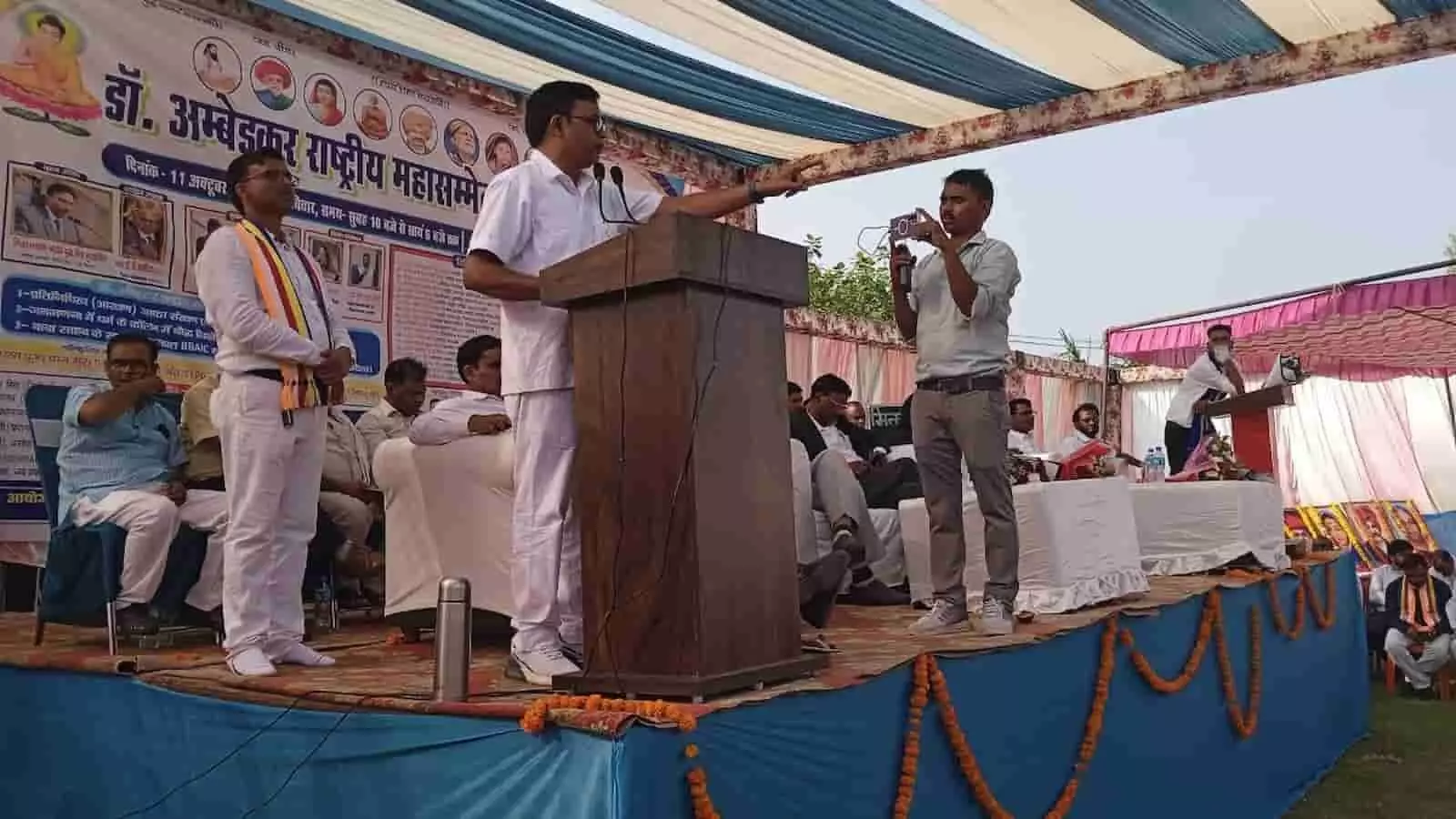 मंच पर पॉडियम से भाषण देते वक्ता और उपस्थित लोग, अंबेडकर महासम्मेलन कार्यक्रम में मंच पर पॉडियम से भाषण देते वक्ता और उपस्थित लोग, अंबेडकर महासम्मेलन कार्यक्रम में