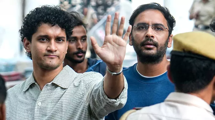 पुलिस हिरासत के दौरान हाथ उठाकर इशारा करते हुए सौरव दास और आशुतोष रांका का दृश्य| पुलिस हिरासत के दौरान हाथ उठाकर इशारा करते हुए सौरव दास और आशुतोष रांका का दृश्य|