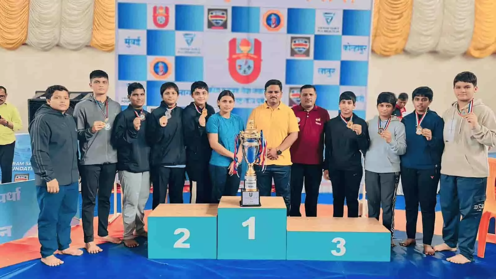 तस्वीर में दिख रही लोकनेते सदाशिवराव मंडलिक राष्ट्रीय कुश्ती संकुल, मुरगूड की महिला पहलवान खोपोली में आयोजित प्रतियोगिता में जीते गए पदकों और ट्रॉफी के साथ प्रसन्न मुद्रा में खड़ी हैं। तस्वीर में दिख रही लोकनेते सदाशिवराव मंडलिक राष्ट्रीय कुश्ती संकुल, मुरगूड की महिला पहलवान खोपोली में आयोजित प्रतियोगिता में जीते गए पदकों और ट्रॉफी के साथ प्रसन्न मुद्रा में खड़ी हैं।