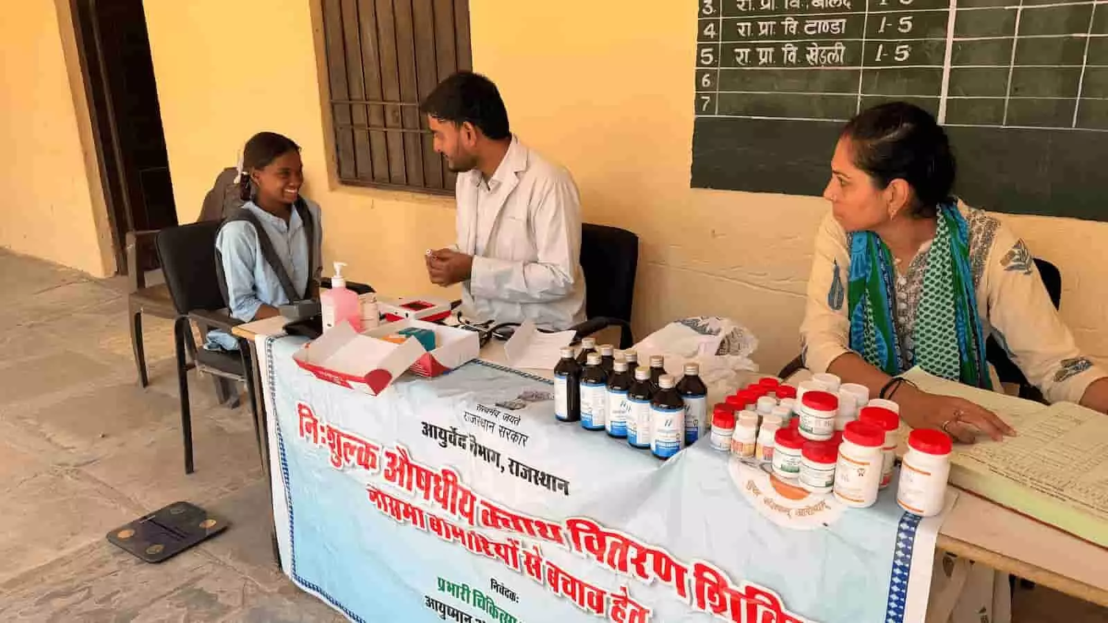 तस्वीर में दिख रहे बूल के स्कूल में लगे आयुर्वेद स्वास्थ्य शिविर में डॉक्टर छात्रा की जाँच कर दवाइयाँ वितरित कर रहे हैं। तस्वीर में दिख रहे बूल के स्कूल में लगे आयुर्वेद स्वास्थ्य शिविर में डॉक्टर छात्रा की जाँच कर दवाइयाँ वितरित कर रहे हैं।