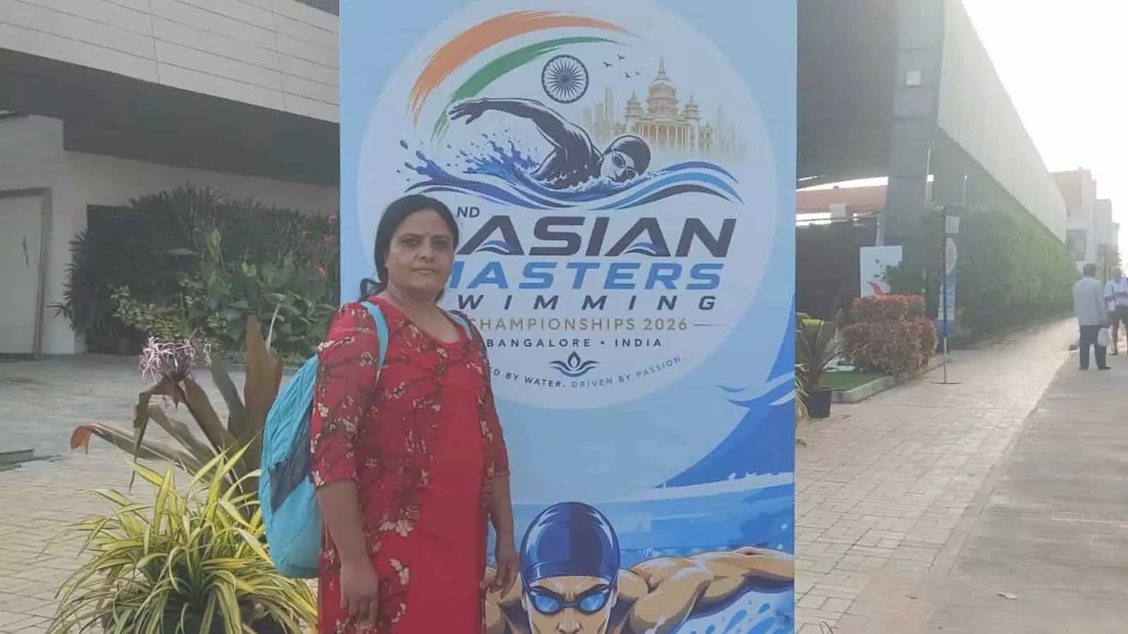 लाल ड्रेस में खड़ी महिला फायरमैन विमला जगरवाल बेंगलुरु में इंटरनेशनल मास्टर्स तैराकी प्रतियोगिता के बैनर के सामने। लाल ड्रेस में खड़ी महिला फायरमैन विमला जगरवाल बेंगलुरु में इंटरनेशनल मास्टर्स तैराकी प्रतियोगिता के बैनर के सामने।