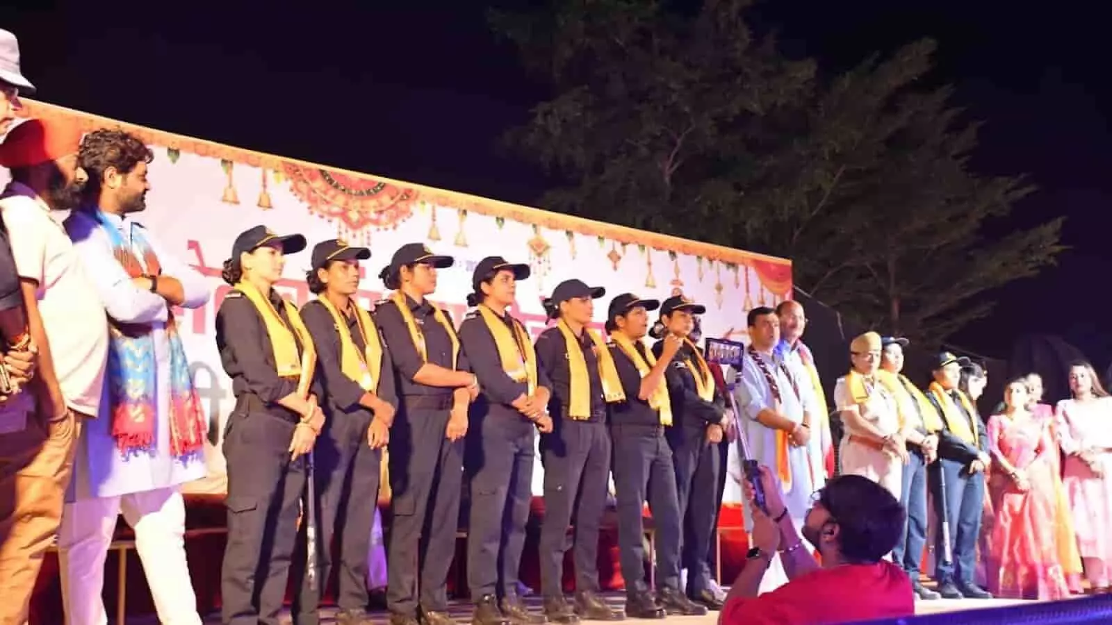 तस्वीर में सादे वस्त्रों में खड़ी महिला पुलिस टीम और नीचे बैठे डिटेन युवक दिख रहे हैं। तस्वीर में सादे वस्त्रों में खड़ी महिला पुलिस टीम और नीचे बैठे डिटेन युवक दिख रहे हैं।