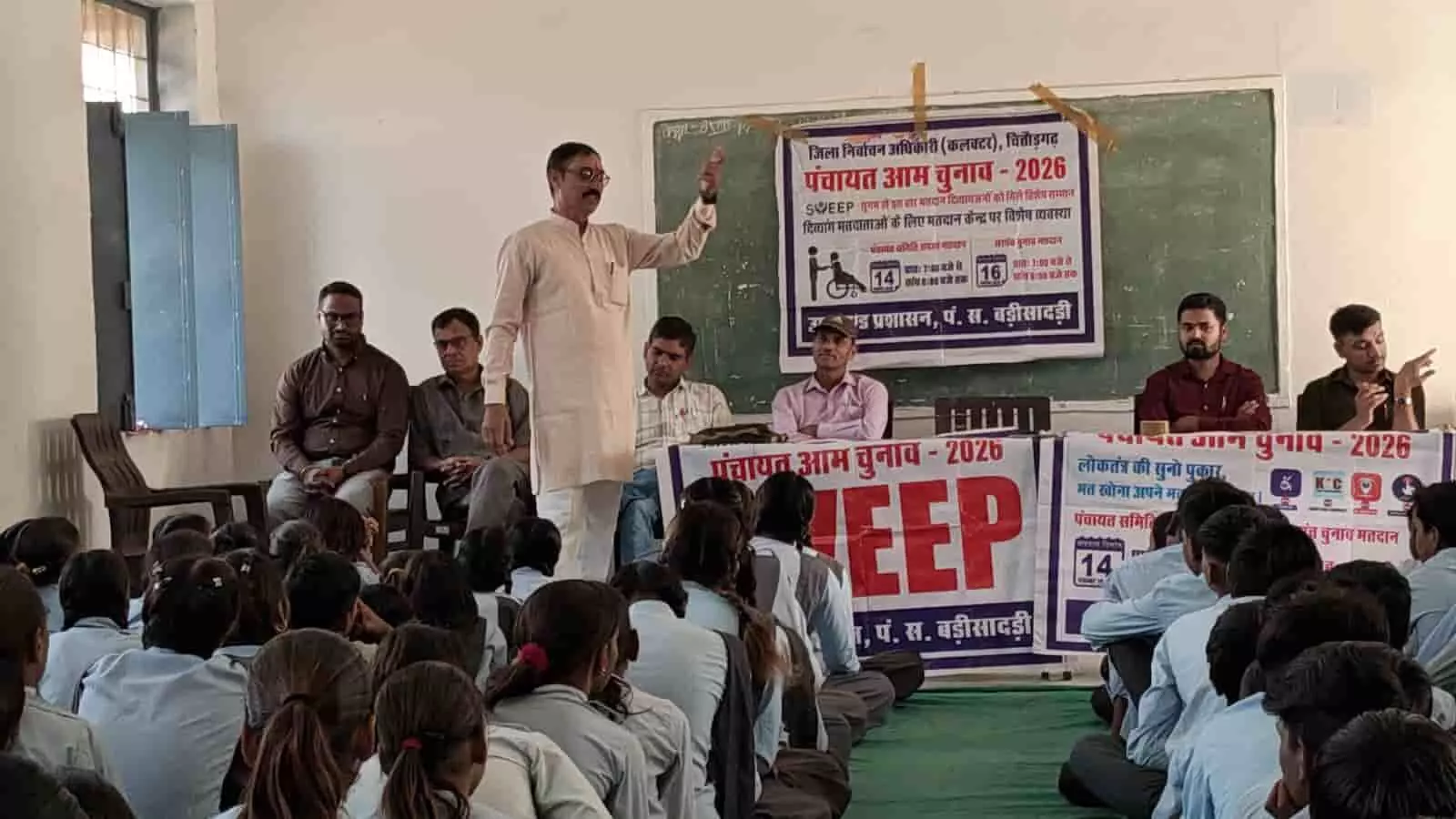 विद्यालय के कक्षा में स्वीप टीम प्रभारी विद्यार्थियों और ग्रामीणों को संबोधित करते हुए। विद्यालय के कक्षा में स्वीप टीम प्रभारी विद्यार्थियों और ग्रामीणों को संबोधित करते हुए।