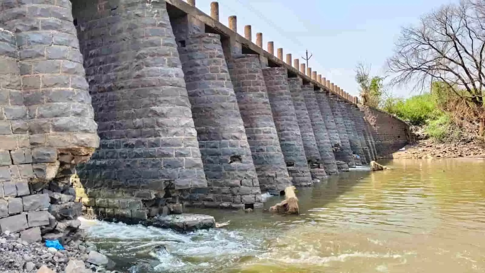 तस्वीर में कोल्हापुर की वेदगंगा नदी पर स्थित क्षतिग्रस्त पत्थरों के पिलर वाला कुरणी बंधारा दिख रहा है। तस्वीर में कोल्हापुर की वेदगंगा नदी पर स्थित क्षतिग्रस्त पत्थरों के पिलर वाला कुरणी बंधारा दिख रहा है।