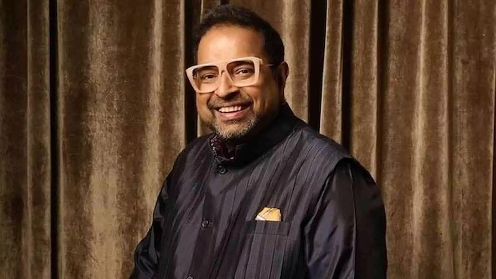 तस्वीर में संगीतकार शंकर महादेवन मुस्कुराते हुए खड़े दिखाई दे रहे हैं। तस्वीर में संगीतकार शंकर महादेवन मुस्कुराते हुए खड़े दिखाई दे रहे हैं।
