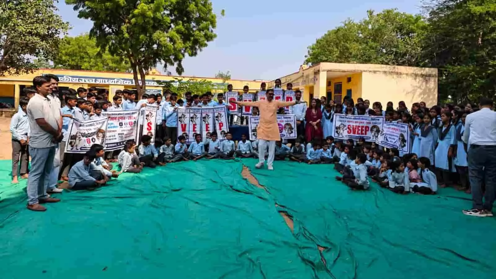 तस्वीर में बड़ी सादड़ी विद्यालय परिसर में स्वीप अभियान के तहत विद्यार्थी और शिक्षक बैनर लेकर खड़े हैं तस्वीर में बड़ी सादड़ी विद्यालय परिसर में स्वीप अभियान के तहत विद्यार्थी और शिक्षक बैनर लेकर खड़े हैं