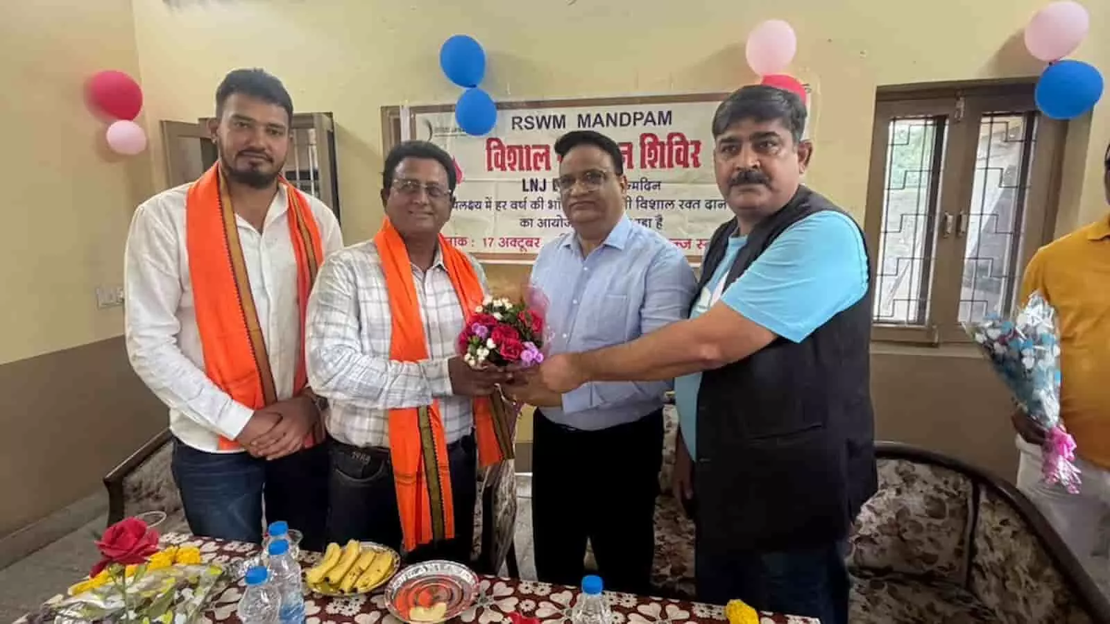 तस्वीर में भीलवाड़ा रक्तदान शिविर के दौरान मंच पर अतिथि गुलदस्ता भेंट करते हुए दिख रहे हैं। तस्वीर में भीलवाड़ा रक्तदान शिविर के दौरान मंच पर अतिथि गुलदस्ता भेंट करते हुए दिख रहे हैं।