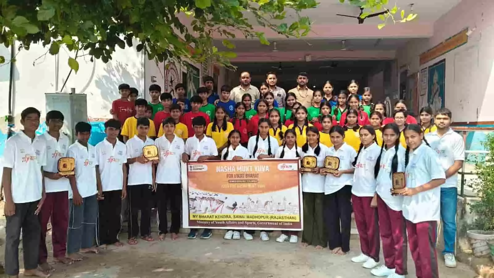 तस्वीर में नशा मुक्त युवा अभियान के दौरान एकलव्य विद्यालय बामनवास में शील्ड थामे विद्यार्थी बैनर के साथ खड़े दिख रहे हैं। तस्वीर में नशा मुक्त युवा अभियान के दौरान एकलव्य विद्यालय बामनवास में शील्ड थामे विद्यार्थी बैनर के साथ खड़े दिख रहे हैं।